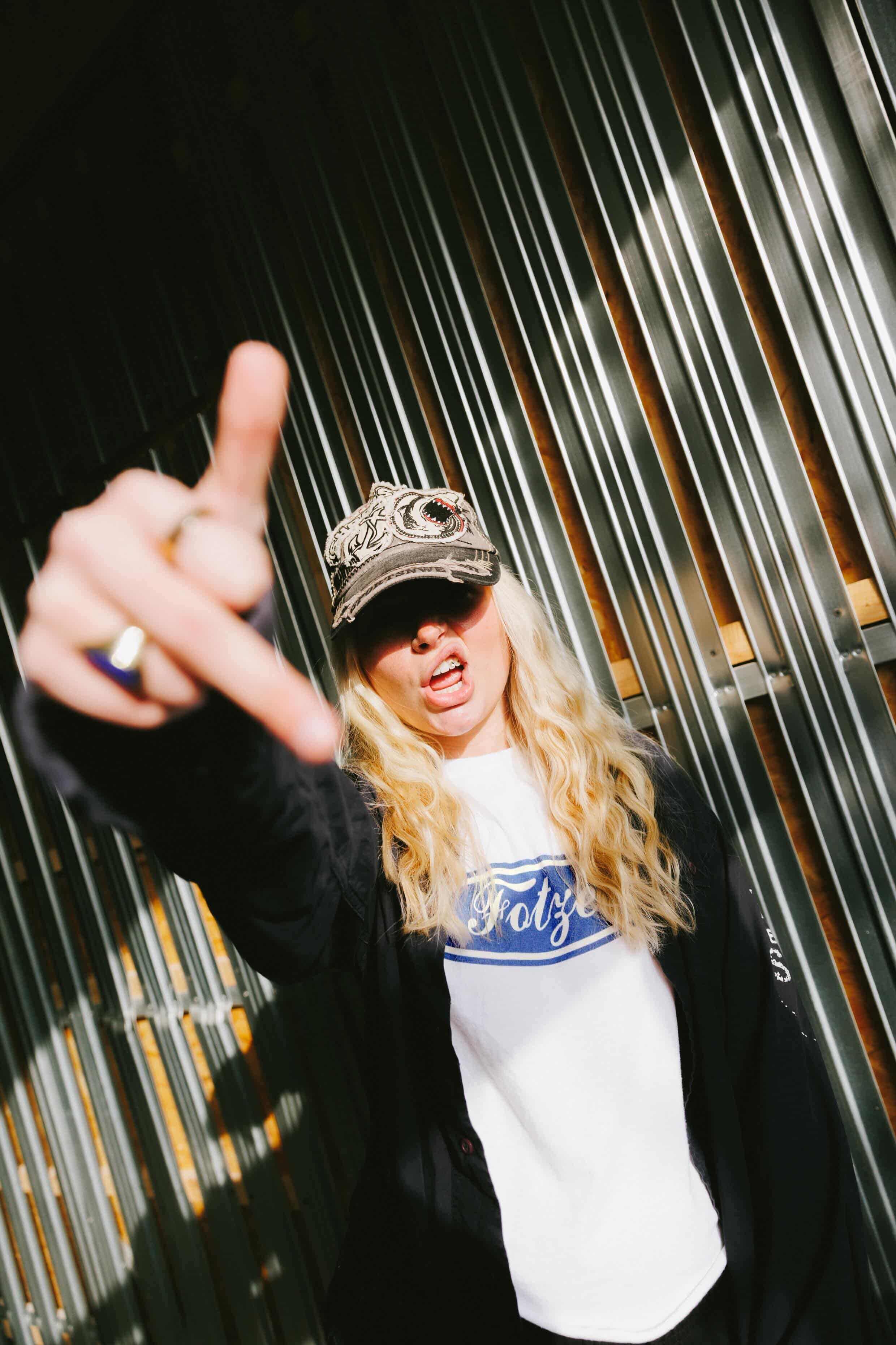 Rapperin Yola zeigt Mittelfinger in die Kamera mit dem Fotze T-Shirt